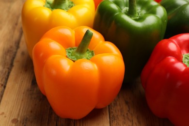 Photo of Fresh colorful bell peppers on wooden table, closeup