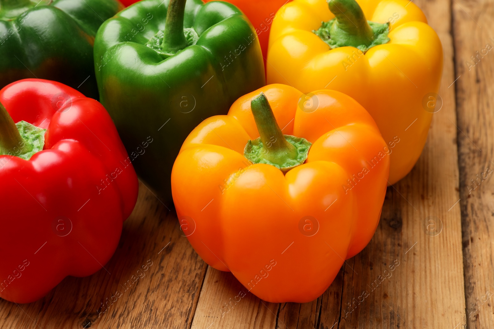 Fresh colorful bell peppers on wooden table, closeup Photo of Fresh colorful bell peppers on wooden table, closeup