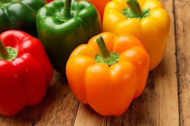 Photo of Fresh colorful bell peppers on wooden table, closeup