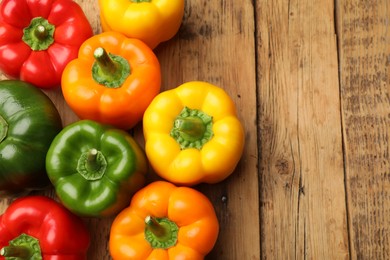 Photo of Fresh colorful bell peppers on wooden table, flat lay. Space for text