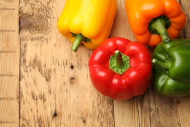 Photo of Fresh colorful bell peppers on wooden table, flat lay. Space for text