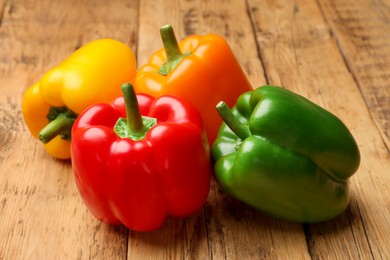 Photo of Fresh colorful bell peppers on wooden table, closeup