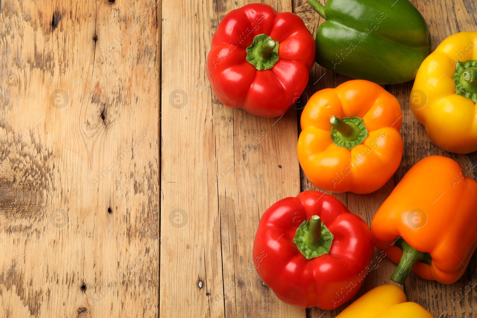 Fresh colorful bell peppers on wooden table, flat lay. Space for text Photo of Fresh colorful bell peppers on wooden table, flat lay. Space for text