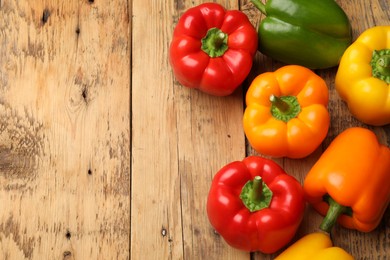 Photo of Fresh colorful bell peppers on wooden table, flat lay. Space for text
