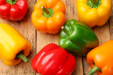 Photo of Fresh colorful bell peppers on wooden table, flat lay