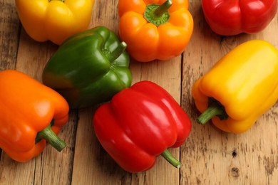 Photo of Fresh colorful bell peppers on wooden table, flat lay