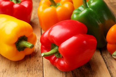 Photo of Fresh colorful bell peppers on wooden table, closeup