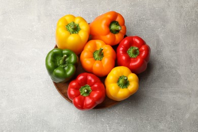 Photo of Fresh colorful bell peppers on gray textured table, top view