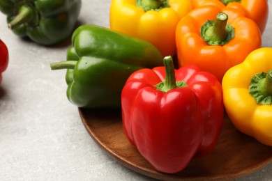 Photo of Fresh colorful bell peppers on gray textured table, closeup