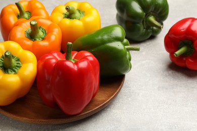 Photo of Fresh colorful bell peppers on gray textured table, closeup
