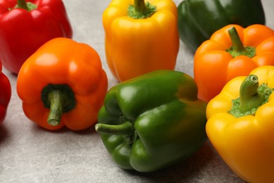 Photo of Fresh colorful bell peppers on gray textured table, closeup
