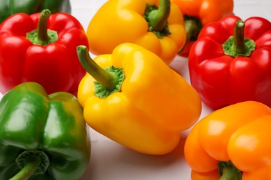Photo of Fresh colorful bell peppers on light table, closeup