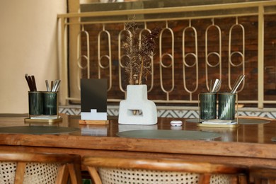 Photo of Stylish setting with cutlery and decor on table in restaurant
