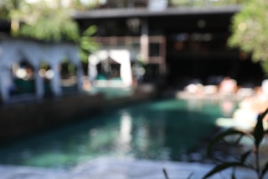 Photo of Blurred view of sunbeds and swimming pool outdoors