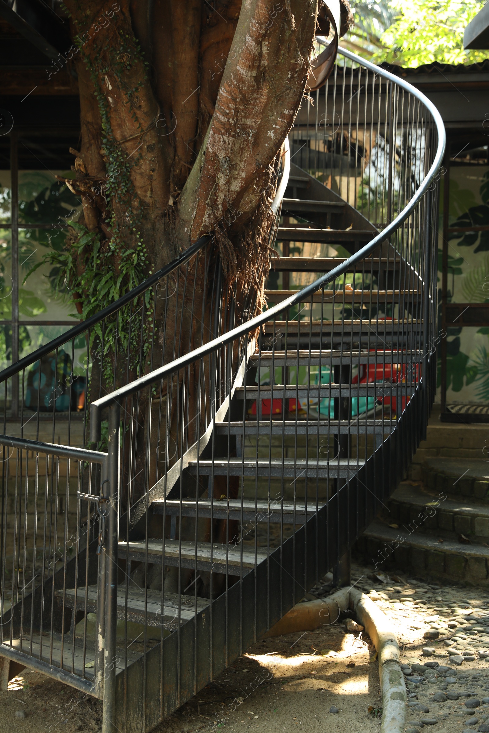 Metal stairs with railings near tree outdoors Photo of Metal stairs with railings near tree outdoors