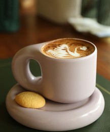 Photo of Aromatic coffee in cup and cookie on table, closeup