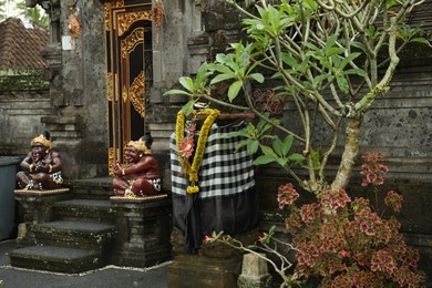 Photo of Bali, Indonesia - May 11, 2025: Entrance of Pura Dalem temple with beautiful statues and other decor outdoors