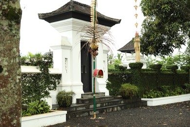 Photo of Bali, Indonesia - May 11, 2025: Entrance of yard, traditional penjor and green plants outdoors