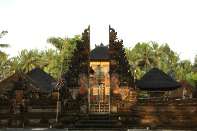 Photo of Bali, Indonesia - May 11, 2025: Exterior of Tirta Empul temple with beautiful ornate gates and green palms