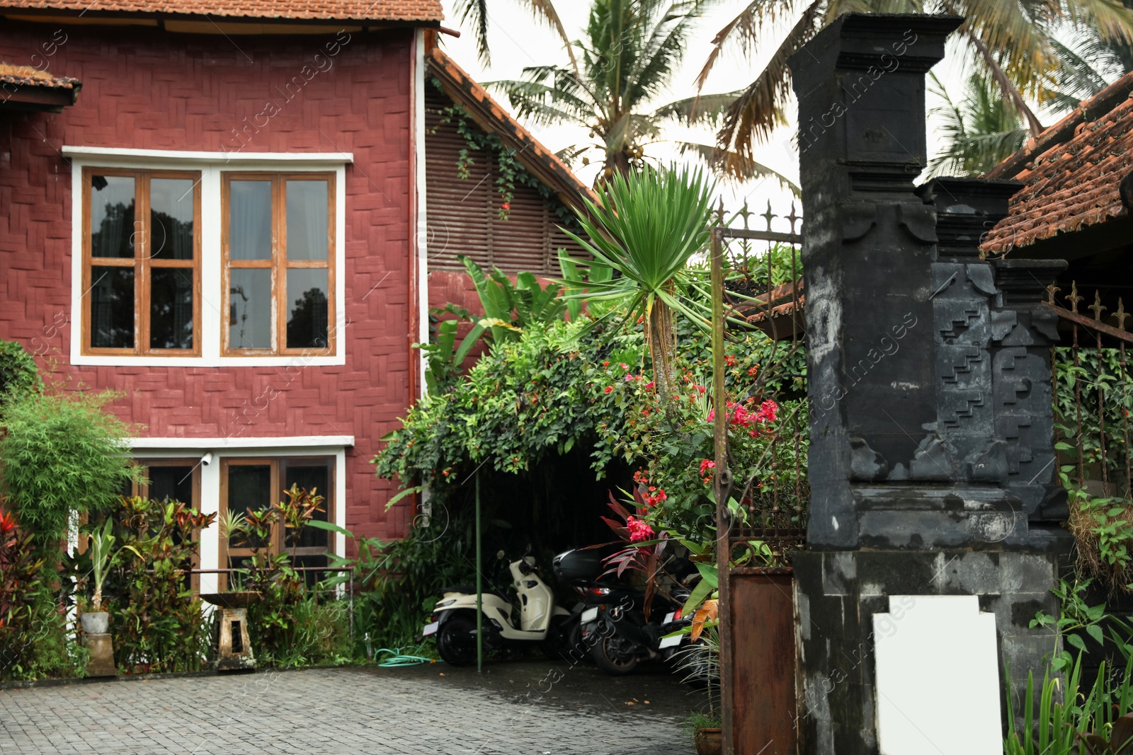Photo of Beautiful building, different plants and scooters outdoors
