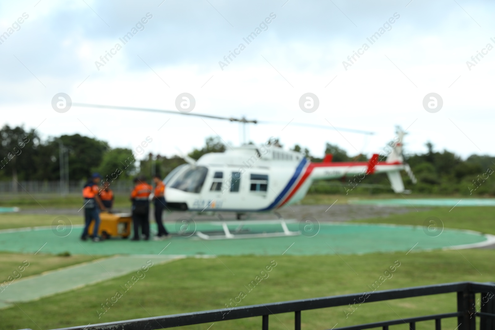 Blurred view of helicopter crew near aircraft at heliport Photo of Blurred view of helicopter crew near aircraft at heliport