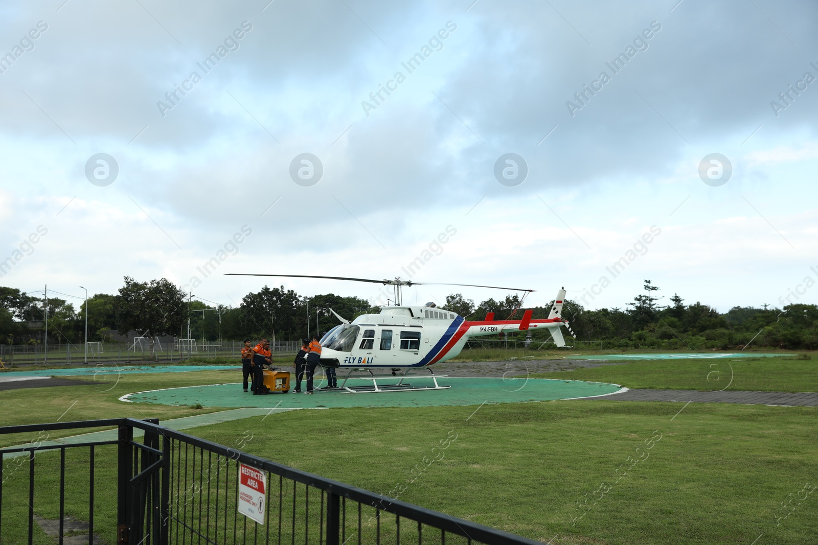 Indonesia, Bali - May 13, 2025: Helicopter crew performing technical procedures in preparation for takeoff at heliport Photo of Indonesia, Bali - May 13, 2025: Helicopter crew performing technical procedures in preparation for takeoff at heliport