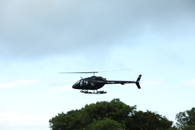 Photo of Indonesia, Bali - May 13, 2025: Black helicopter flying in sky
