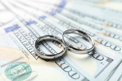 Photo of Two silver wedding rings on dollar banknotes, closeup
