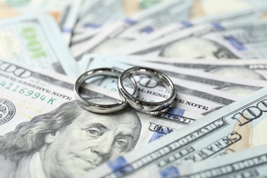 Photo of Two silver wedding rings on dollar banknotes, closeup