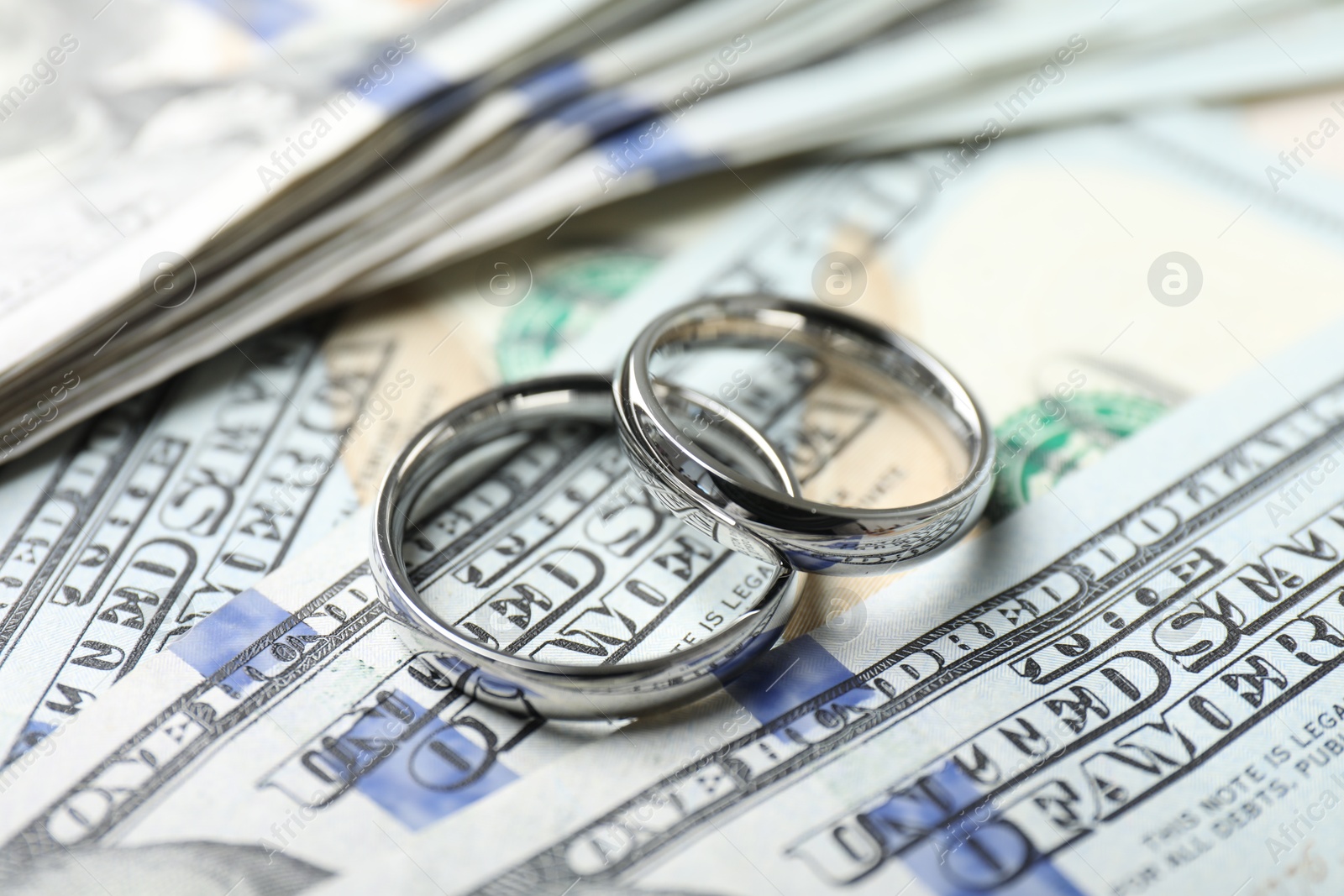 Photo of Two silver wedding rings on dollar banknotes, closeup