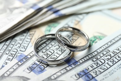 Photo of Two silver wedding rings on dollar banknotes, closeup