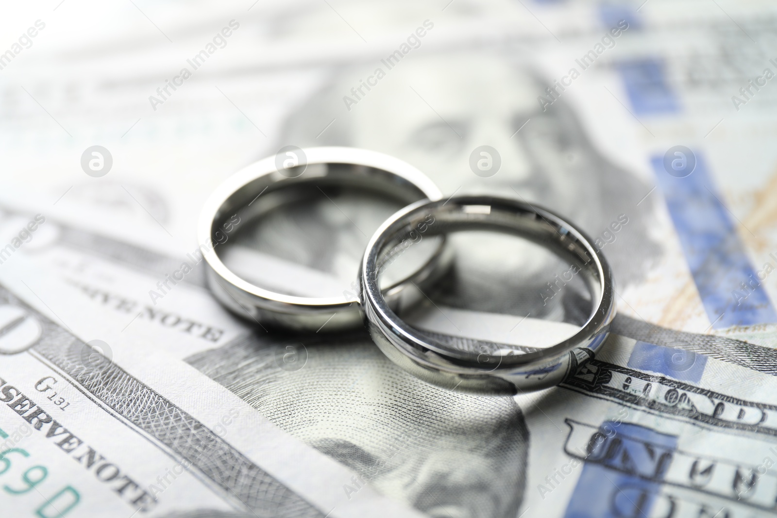 Photo of Two silver wedding rings on dollar banknotes, closeup