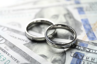 Photo of Two silver wedding rings on dollar banknotes, closeup