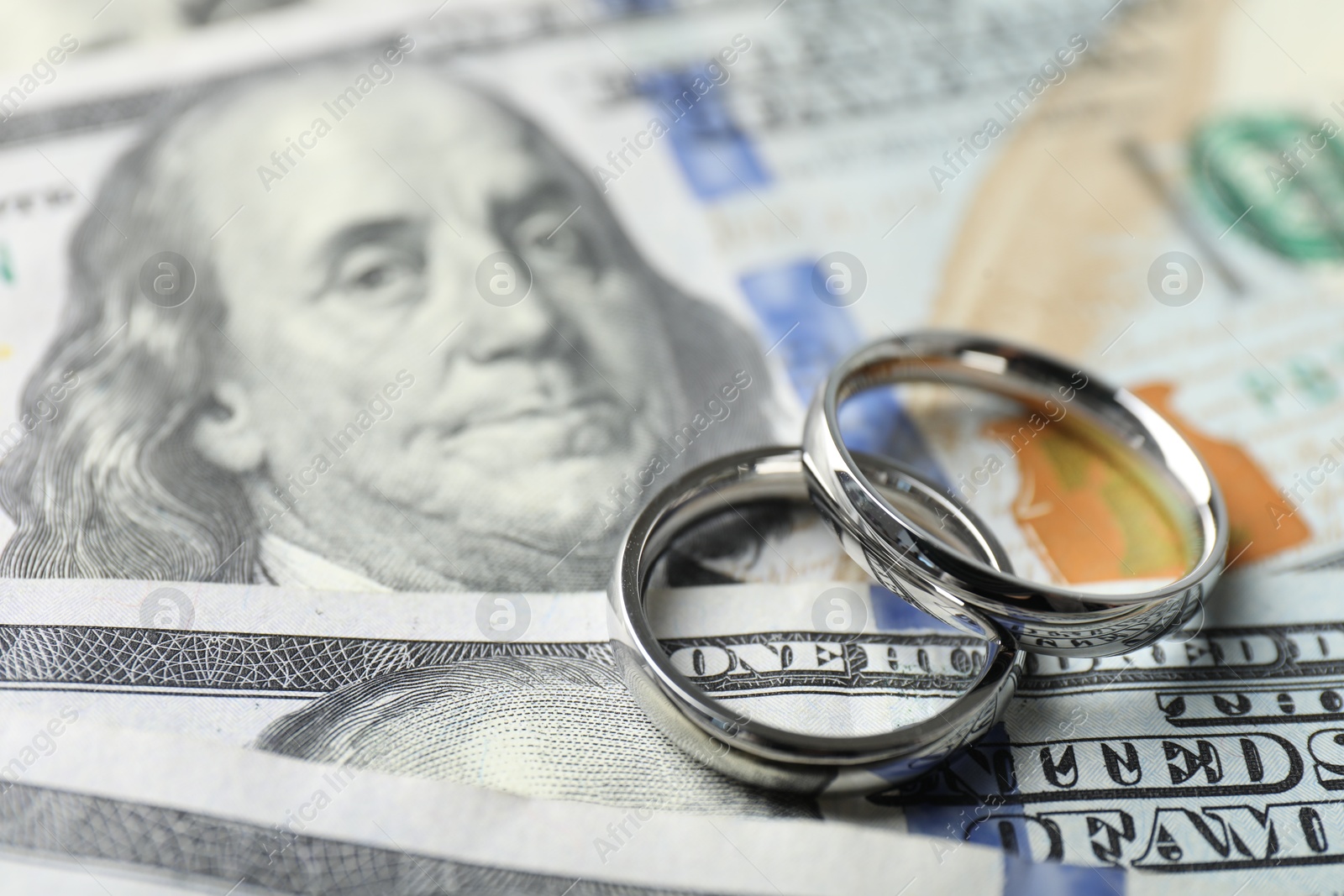 Photo of Two silver wedding rings on dollar banknotes, closeup