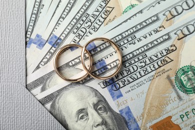 Photo of Two gold wedding rings, dollar banknotes and envelope, top view