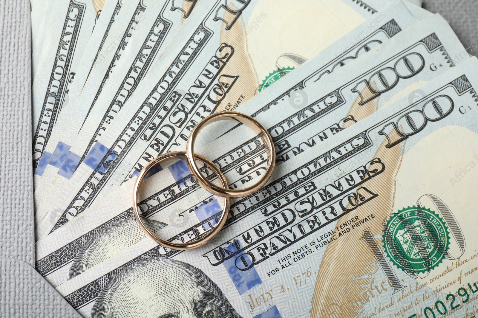 Photo of Two gold wedding rings, dollar banknotes and envelope, top view