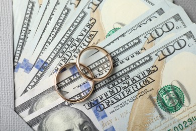Photo of Two gold wedding rings, dollar banknotes and envelope, top view