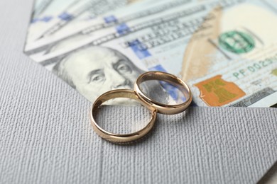 Photo of Two gold wedding rings, dollar banknotes and envelope, closeup