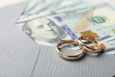 Photo of Two gold wedding rings, dollar banknotes and envelope, closeup