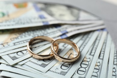 Photo of Two gold wedding rings, dollar banknotes and envelope, closeup