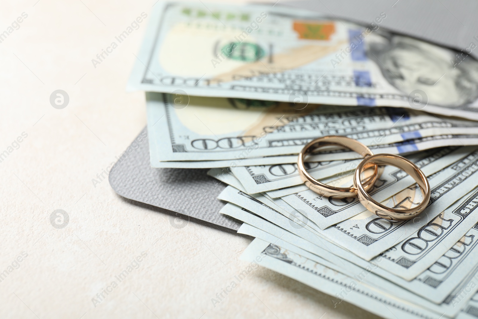 Photo of Two gold wedding rings, dollar banknotes and envelope on white table, closeup. Space for text