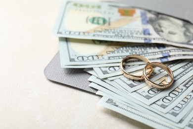 Photo of Two gold wedding rings, dollar banknotes and envelope on white table, closeup. Space for text