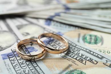 Photo of Two gold wedding rings on dollar banknotes, closeup
