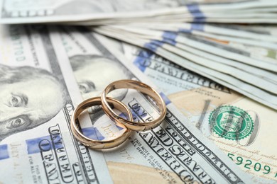 Photo of Two gold wedding rings on dollar banknotes, closeup