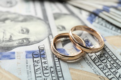 Photo of Two gold wedding rings on dollar banknotes, closeup