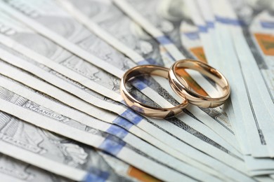 Photo of Two gold wedding rings on dollar banknotes, closeup