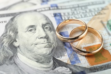 Photo of Two gold wedding rings on dollar banknotes, closeup
