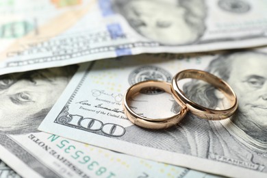 Photo of Two gold wedding rings on dollar banknotes, closeup