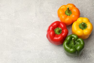 Photo of Fresh colorful bell peppers on gray textured table, flat lay. Space for text