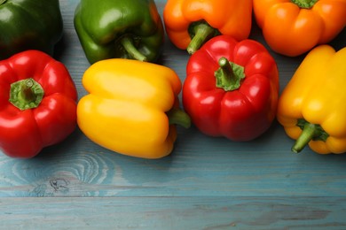 Photo of Fresh colorful bell peppers on blue wooden table, flat lay
